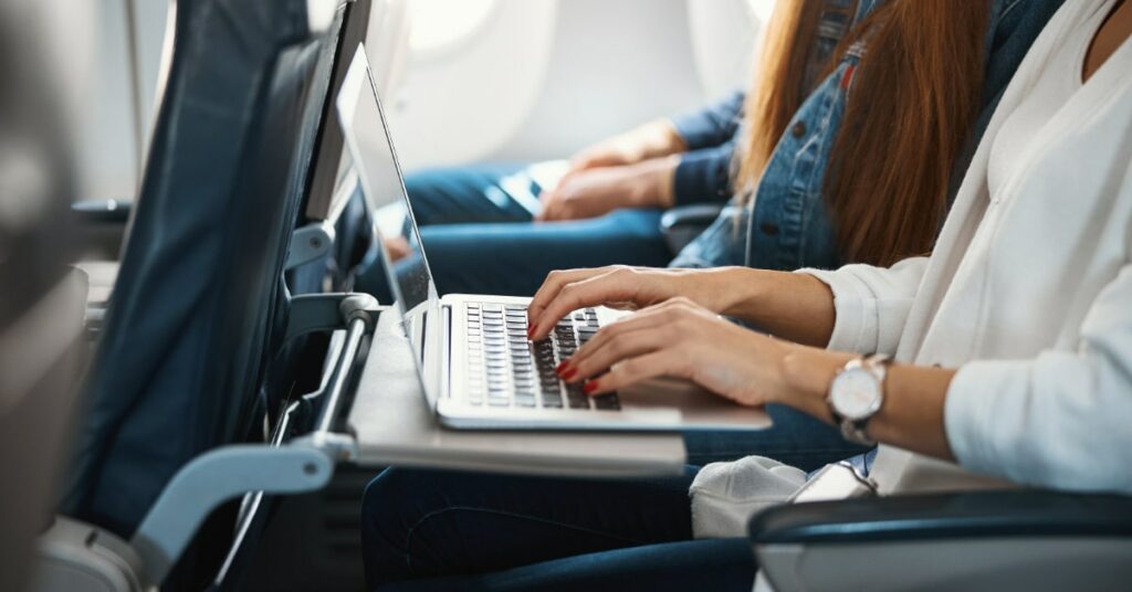 Passenger Using Laptop On Flight